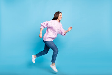 Full length profile side photo of young woman happy positive smile jump go walk run hurry sale isolated over blue color background