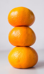 tower of three mandarines on white background