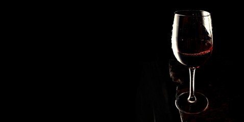 Red wine in glass on dark old board