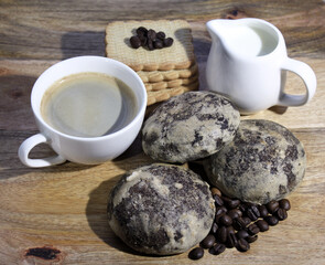 white cup americano with gingerbread and cookies on a wooden table. a cup of coffee and a cup of cream. breakfast with gingerbread and cookies.