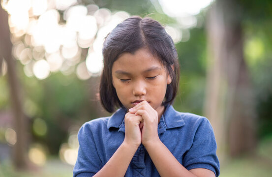Prayer concept. Asian child praying, hope for peace and free from coronavirus, Hand in hand together by kid, believes and faith in christian religion at church.
