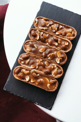 Peanut dessert in a cafe on a black plate. Vegan food.