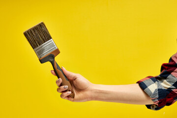 paint brush on a bright yellow background. paint tool. home repair or tool concept copy space, close-up