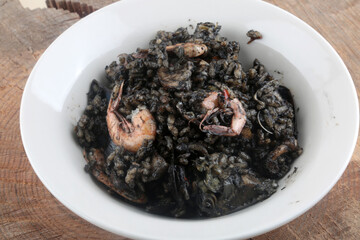 seafood black rice with aquid ink as typical spanish dish