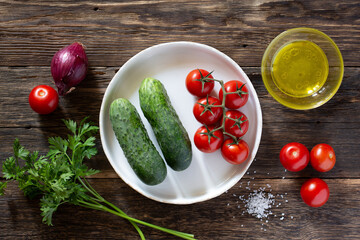 Fresh vegetables tomatoes and cucumbers on a rustic table