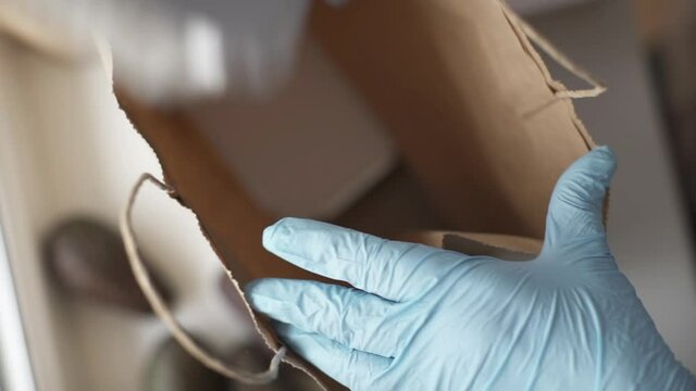 Woman wearing protective mask and gloves packing food boxed take away. Food delivery services.