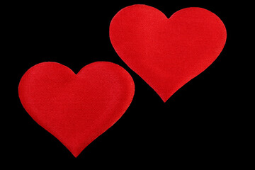 two red hearts isolated on black background