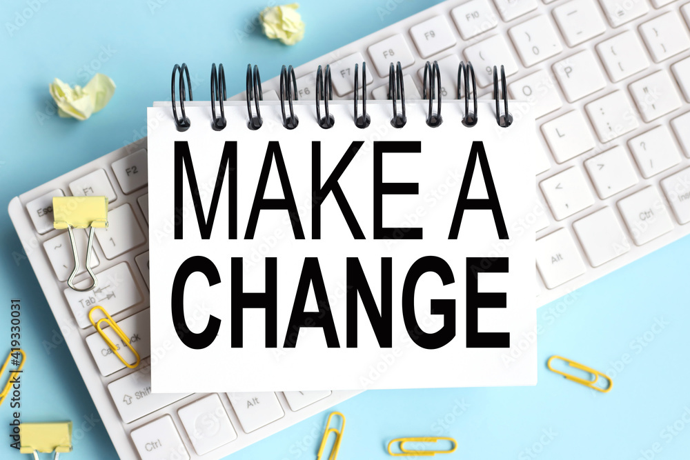 Poster make a change. text on white notepad paper on white keyboard