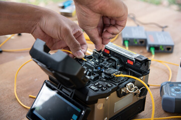 technician welding optical fiber cable with fusion splicing fiber optic Machine., pad cot cable