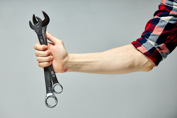 two wrench composition in male hands isolated on gray , tools for repair. copy space
