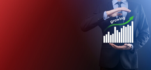 Business man holding holographic graphs and stock market statistics gain profits. Concept of growth planning and business strategy. Display of good economy form digital screen.