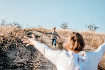 Mothers Day, celebrates motherhood, holiday in honor of mothers. Little boy kid son runing into the arms of his mother in nature background. Selective focus