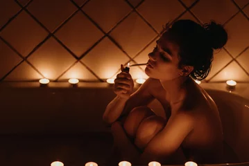 sexy nude girl smoking a cigarette sitting in the bath © alexkoral