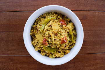 Traditional Indian fasting food recipe dish called Bhagar homemade of Barnyad millet rice grains. Also known as samo or sama pulao rice khichdi. Indian fasting food dish on wooden background - obrazy, fototapety, plakaty