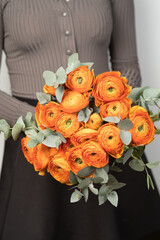 A bouquet of bright orange ranunculus close-up.