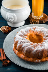 Bundt cake with sugar powder with copy space. Homemade ring cake with icing sugar on wooden table, closeup, rustic style.