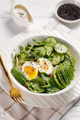 bowl with quinoa, greens, avocado and boiled egg