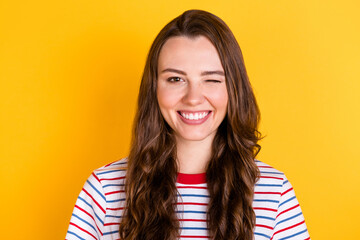 Photo of charming sweet young woman wear striped outfit smiling winking isolated yellow color...