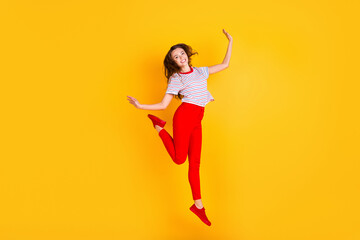 Fototapeta na wymiar Photo of charming crazy lady jump enjoy wear striped shirt red pants shoes isolated yellow color background
