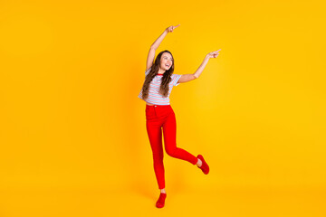Fototapeta na wymiar Full body photo of young cheerful girl happy positive smile look indicate fingers empty space isolated over yellow color background