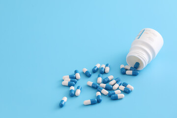 pills capsules with bottle isolated on blue background