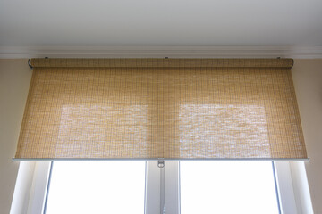 Roller blinds made of thin bamboo on the window