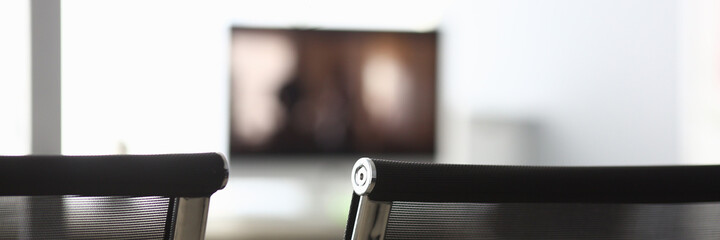 Close-up of room for conversation with black armchairs, computer monitor and other supplies for...