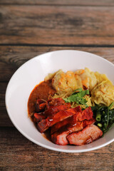 Shrimp dumpling with roasted pork with local thai tom yum spicy sauce on wood background