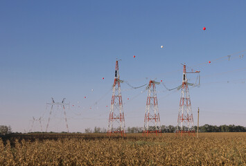 High voltage power line with red balls for warning pilots, low flying aircraft and helecopter.