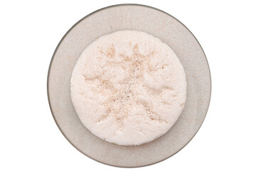 Raw, ripening yeast in a glass dish, isolated on a white background, top view.