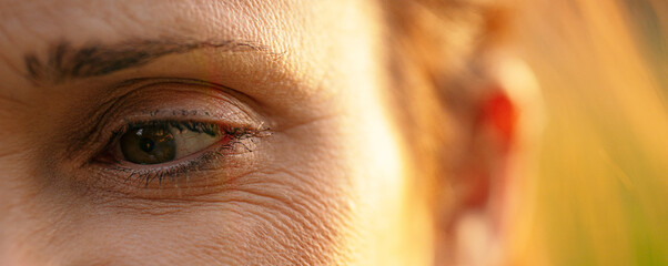macro shot of middle aged woman's eye with wrinkles. withered skin concept