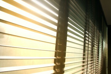 Evening sun light outside wooden window blinds, sunshine and shadow on window blinds , decorative interior home concept