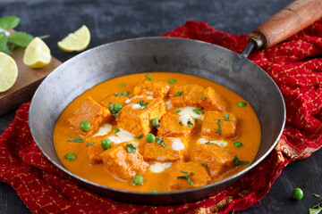 Matar Paneer curry, paneer butter masala recipe made using cottage cheese, green peas, served in a bowl.  Delhi, Rajasthan India. Indian veg curry wooden background. side dish of Roti, Chapati, naan