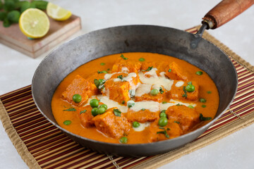 Matar Paneer curry, paneer butter masala recipe made using cottage cheese, green peas, served in a bowl.  Delhi, Rajasthan India. Indian veg curry wooden background. side dish of Roti, Chapati, naan