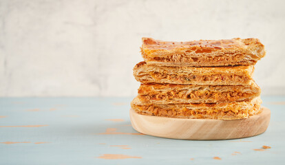 Closeup of portions of empanada with ingredients such a tomato, onion, pepper, tuna, egg and dough on a white background with copy space. Tuna pie. Typical Galician dish from Galicia and Spain