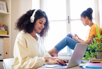 Obraz premium Portrait of student with laptop indoors at home, e-learning concept.