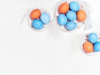 Colored eggs on plate with on white background. Flat lay. Copy space.  Easter concept. Top view.