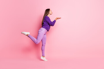 Full size profile photo of optimistic girl blow kiss wear lilac sweater sneakers isolated on pastel pink color background