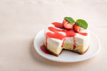 Classic cheesecake with fresh berries on white plate.