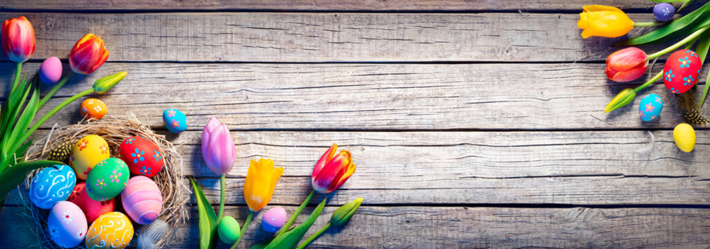 Easter - Decorated Eggs In Nest With Colorful Tulips On Wooden Plank