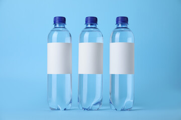 Plastic bottles with soda water on light blue background
