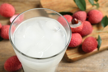 Glass with fresh lychee juice on table, closeup