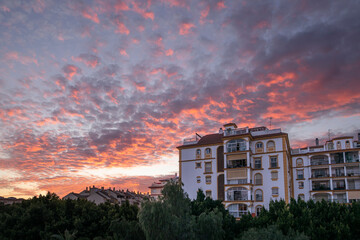 Imagen de un espectacular atardecer con un cielo cubierto de nubes rojas, sobre un edificio , en Fuengirola Malaga.