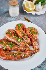 Grilled large queen shrimps with lemon and spices on the plate