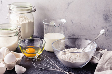 Cooking ingredients for dough, eggs, flour, sugar, milk.