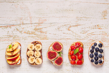 Homemade summer toast with cream cheese, nut butter and fruits and berries