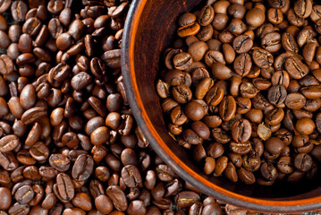 Coffee beans close up. Coffee in a clay bowl.
