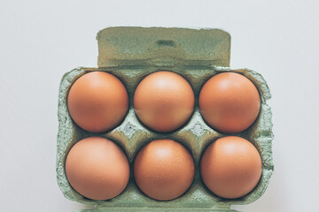 chicken eggs in a cardboard box on white background
