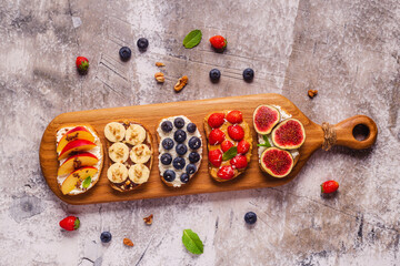 Homemade summer toast with cream cheese, nut butter and fruits and berries