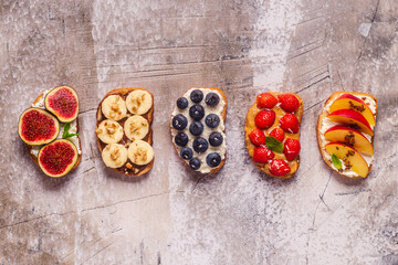 Fototapeta na wymiar Homemade summer toast with cream cheese, nut butter and fruits and berries